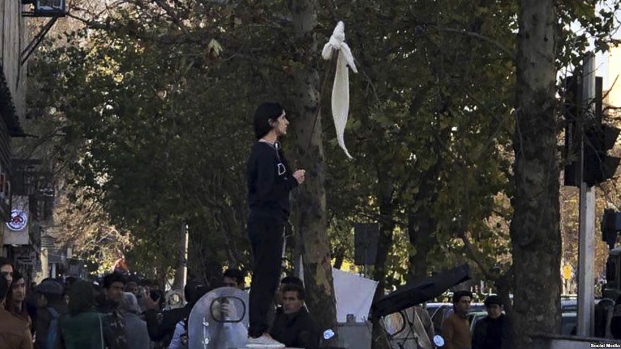 Vida Movahedi stands on a telecoms box on a Tehran street after removing her headscarf and holding a stick to protest against the country's compulsory hijab rules.