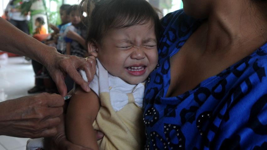 A mother holds her child as she receives a measles vaccine at the Department of Health (DOH) headquarters in Manila on January 21, 2014. The DOH announced a nationwide campaign against measles, targeting 13 million children aged up to five years old. AFP PHOTO / NOEL CELIS / AFP PHOTO / NOEL CELIS        (Photo credit should read NOEL CELIS/AFP/Getty Images)