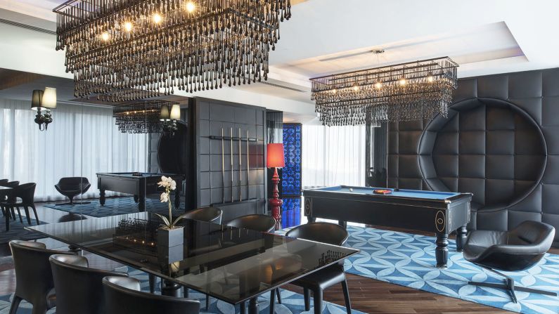<strong>Playtime:</strong> This spacious 300 square meter suite is decked out in black and blue. You can hang in a swing chair, play pool with your friends, then have your meal catered through your own private kitchen and sit down for a meal at your own private dining table. 