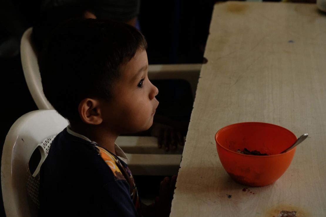 Imael, 5, with a bowl of rice and beans, his only meal of the day.