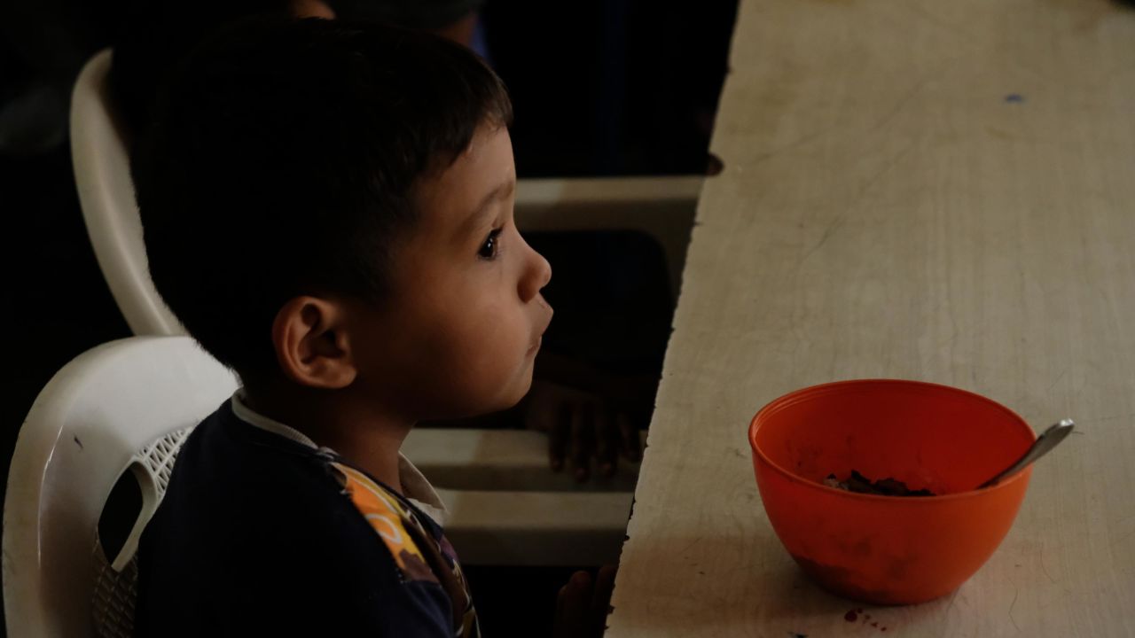 Imael, 5, with a bowl of rice and beans, his only meal of the day.