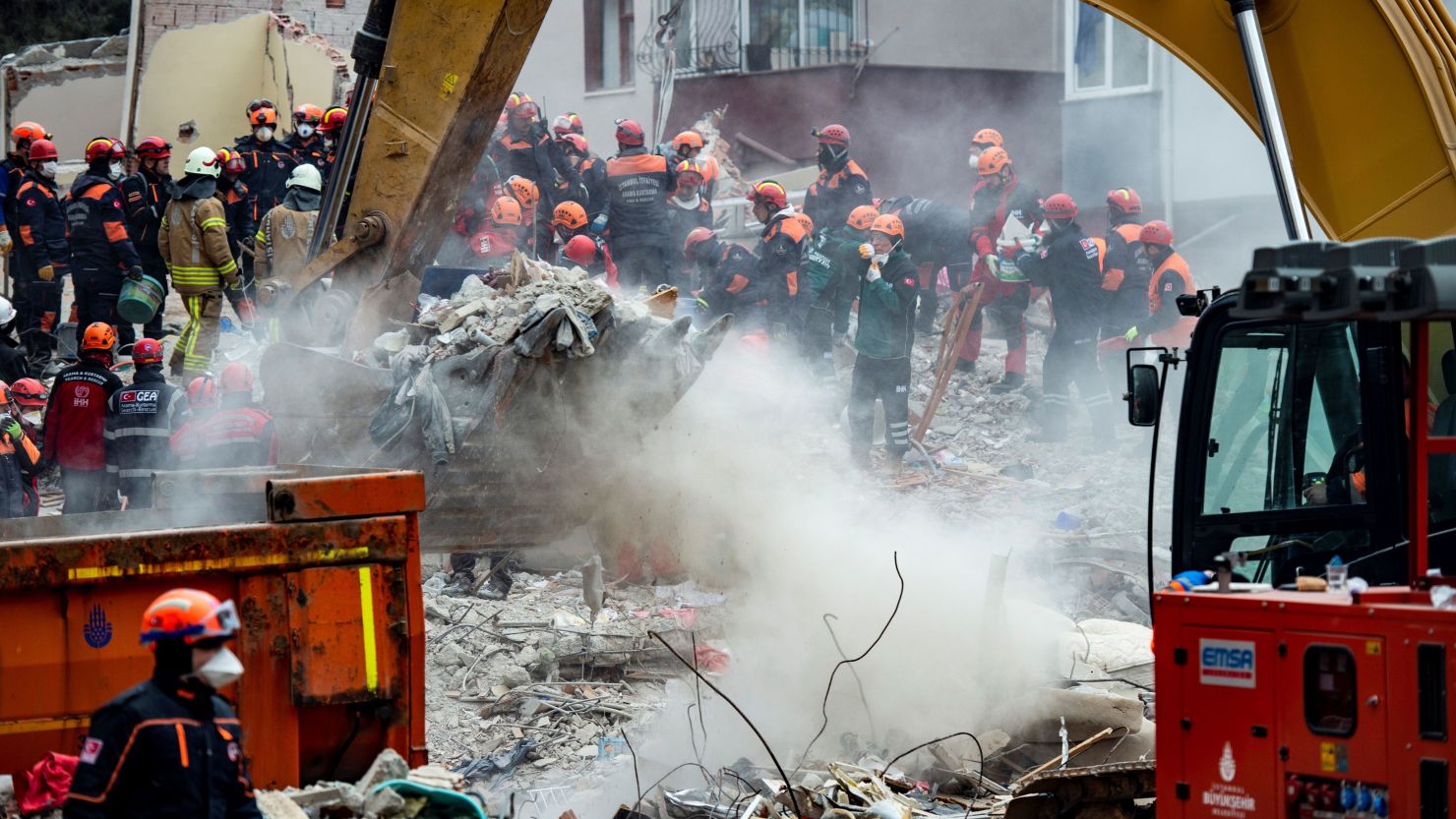 Rescue workers are seen Thursday searching the rubble of the residential building.