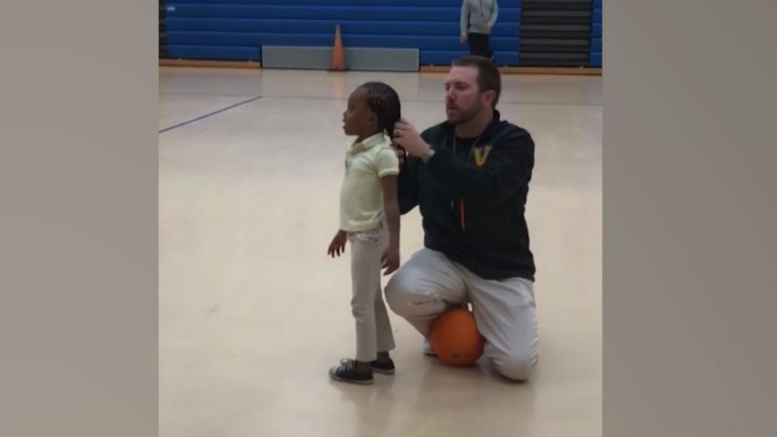 Gym teacher fixes student's ponytail