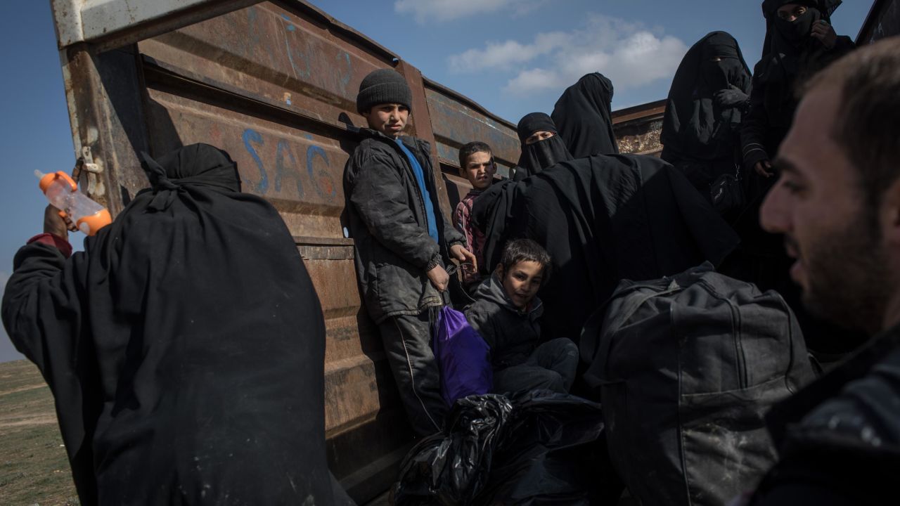 Civilians who fled fighting in Baghouz Al-Fawqani board trucks Saturday after being screened by the Syrian Democratic Forces.
