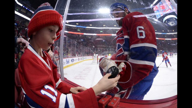 Montreal captain Shea Weber gives a puck to a young fan before an NHL game on Thursday, February 7.