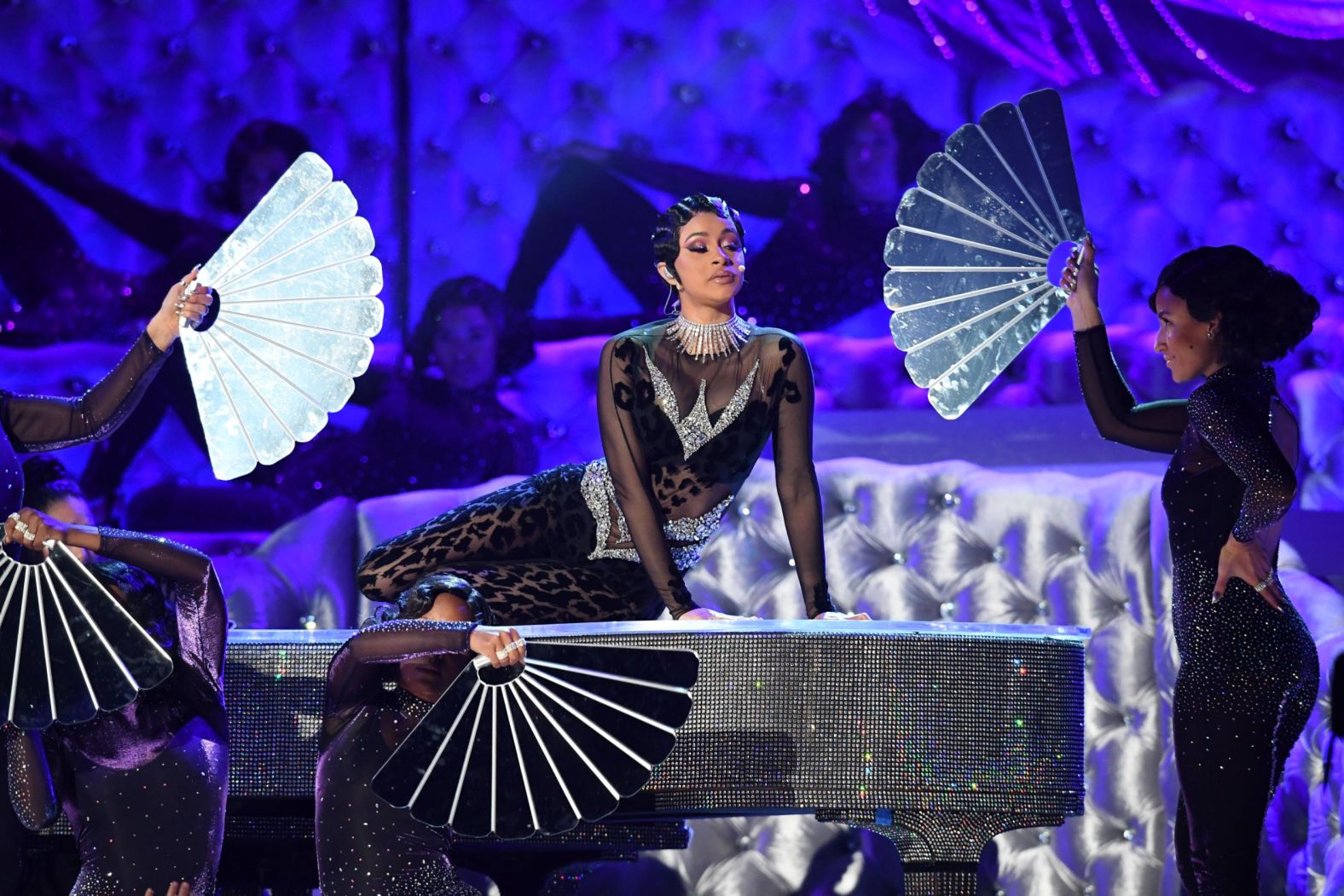 Rapper Cardi B is fanned on a piano during a performance of her song "Money."