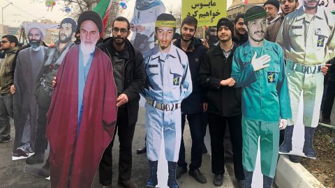 Protesters carry life-sized cardboard images of iconic revolutionary figures, including Supreme Leader Rouhallah Khomeini. 
