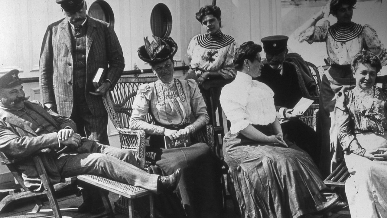 A woman daringly displays her forearms on a sailing to the Mediterranean in the early 1900s.