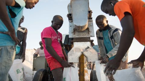 Men working for Diouf use an iodization machine donated by NGO Nutrition International to mix potassium iodate into the salt before packaging.
