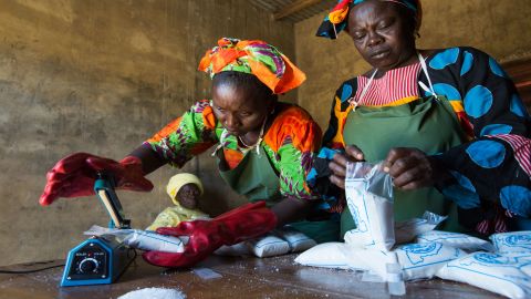 Ndeye Faye, top left, and Seynabou Diouf, right, test salt for iodine content before sealing it in plastic bags, while Fatou Sarr, bottom left, looks on. Marie Diouf employs the women in her micro-business producing and packaging iodized salt.