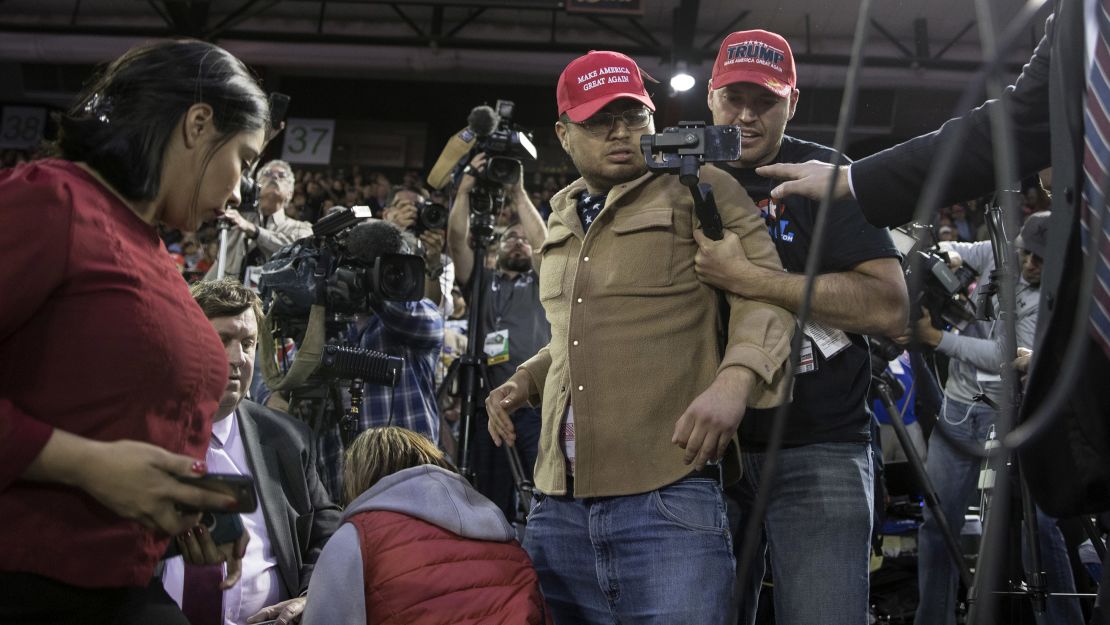 A man is restrained after he entered the media area during a Trump rally in El Paso.