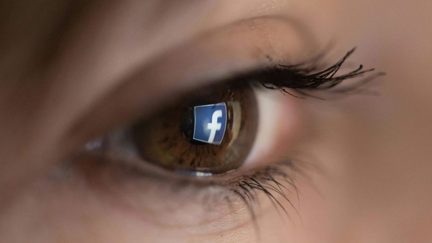 An illustration picture taken on March 22, 2018 in Paris shows a close-up of the Facebook logo in the eye of an AFP staff member posing while she looks at a flipped logo of Facebook. (Photo by Christophe SIMON / AFP)        (Photo credit should read CHRISTOPHE SIMON/AFP/Getty Images)