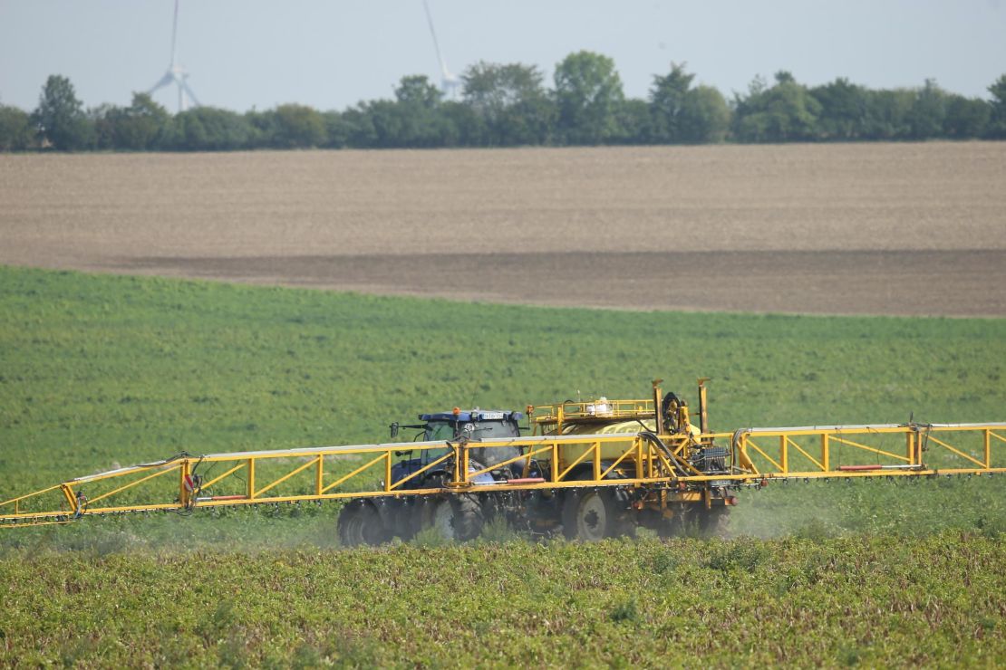 A tractor sprays pesticide onto a field of potato plants near Aschersleben, Germany, in August 2017.