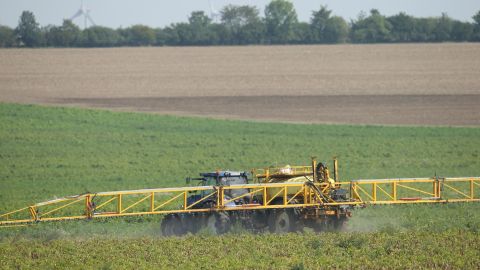 A tractor sprays pesticide onto a field of potato plants near Aschersleben, Germany, in August 2017.