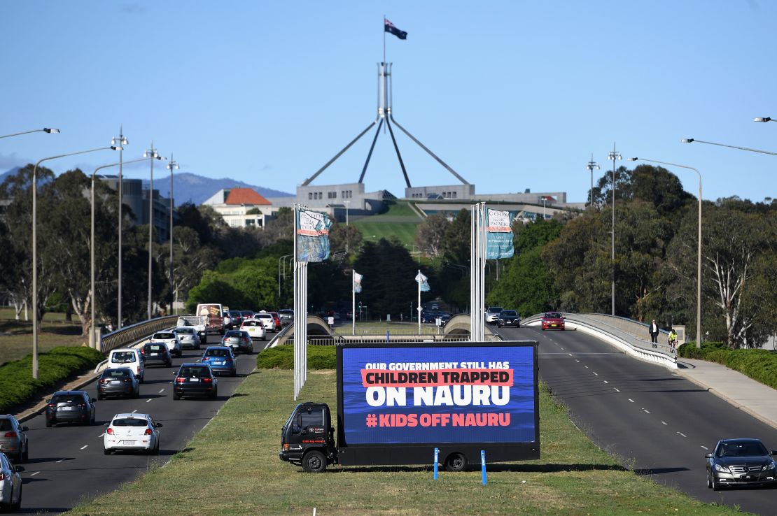 A billboard protesting the detention of children on Nauru sits outside of  Parliament House on November 26 in Canberra.