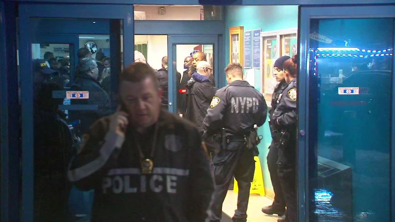 Members of the NYPD wait outside the hospital where an officer is being treated for a gunshot wound from a robbery of a cell phone store Tuesday February 12, 2019.