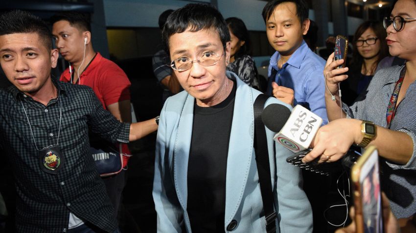 Philippine journalist Maria Ressa (C) is surrounded by the press as she is escorted by a National Bureau Investigation (NBI) agent (L) at the NBI headquarters after her arrest in Manila on February 13, 2019. - Ressa, who has repeatedly clashed with President Rodrigo Duterte, was arrested in her Manila office on February 13 in what rights advocates called an act of "persecution". (Photo by TED ALJIBE / AFP) (Photo credit should read TED ALJIBE/AFP/Getty Images)