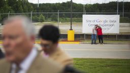 Workers take a selfie at the site of a proposed $300 million expansion of Google's data center operations as Georgia Gov. Nathan Deal, left, talks to reporters following a ceremony Tuesday, June 2, 2015, in Lithia Springs, Ga. The new facility will be located next to the existing data center, one of 13 in the world, and will add 25 jobs to the 350 employees currently employed there by Google. The new facility is scheduled to be operational by the end of 2016. (AP Photo/David Goldman)