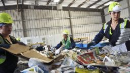 UNITED STATES - AUGUST 14:  Vacilia Rubio, left, Catalina Gonzalez, center, and Yarida Colia sort recyclable paper and cardboard trash at Waste Management Inc.'s Davis Street Recycling Facility in San Leandro, California, U.S., on Thursday, Aug. 14, 2008. Waste Management, the U.S. trash hauler trying to buy competitor Republic Services Inc., may need to offer stock if it wants to raise its all-cash, $6.73-billion bid without risking a ratings downgrade, analysts said.  (Photo by Ryan Anson/Bloomberg via Getty Images)