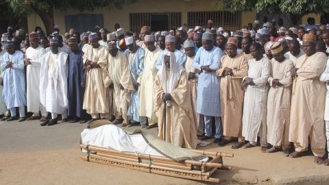 Men attend the burial prayer Thursday of a victim of an attack on the Borno State governor's convoy.