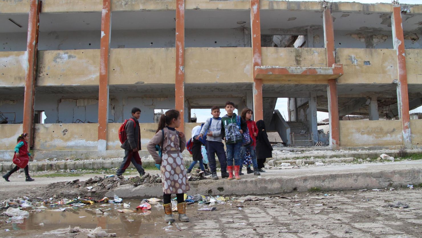 Syrian children stand in January in the courtyard of a school hit by bombardment in mostly rebel-held Idlib province. 