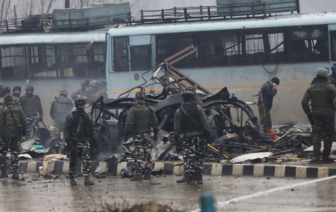 Indian security forces inspect the remains of a bus following a deadly attack on a paramilitary Central Reserve Police Force (CRPF) convoy.
