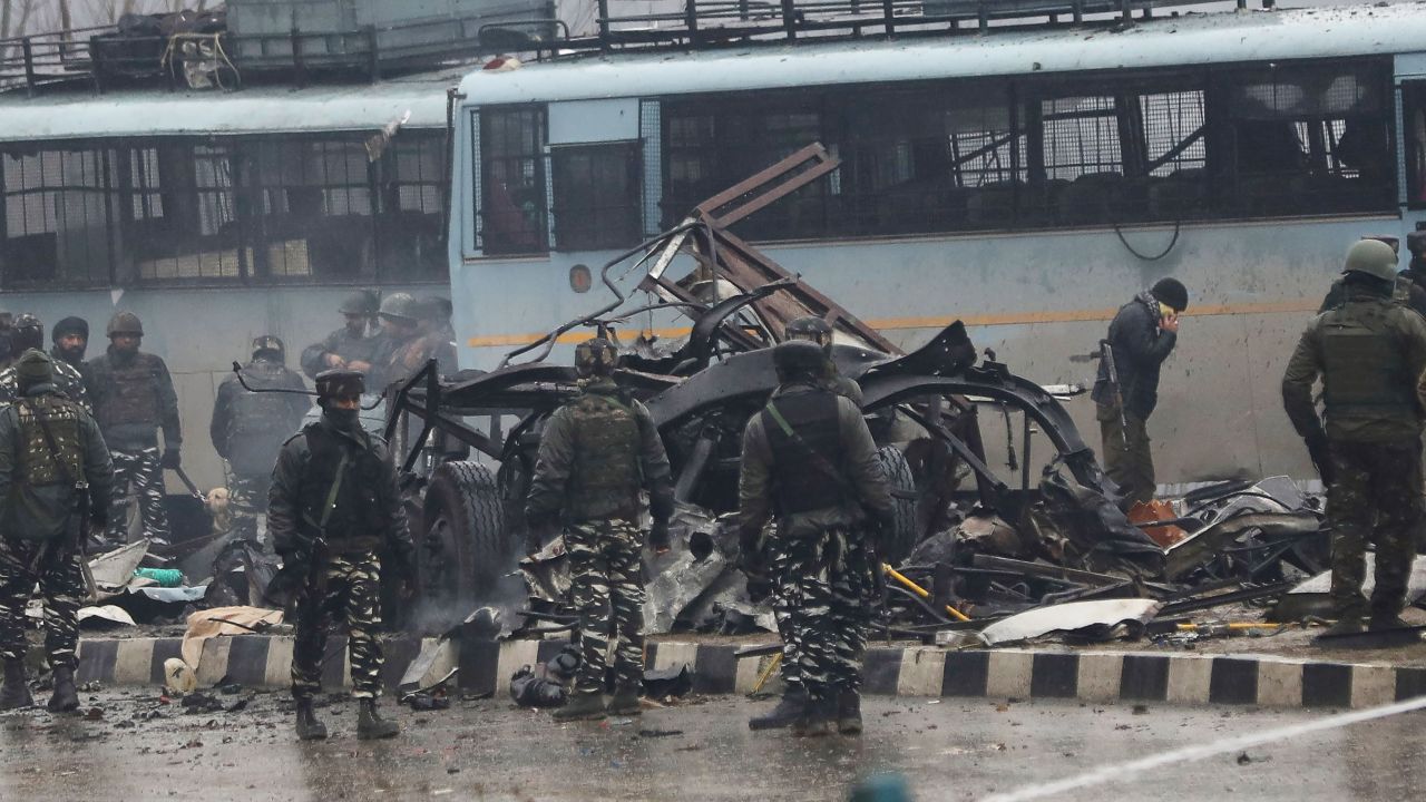 Indian security forces inspect the scene of an attack on a paramilitary convoy.