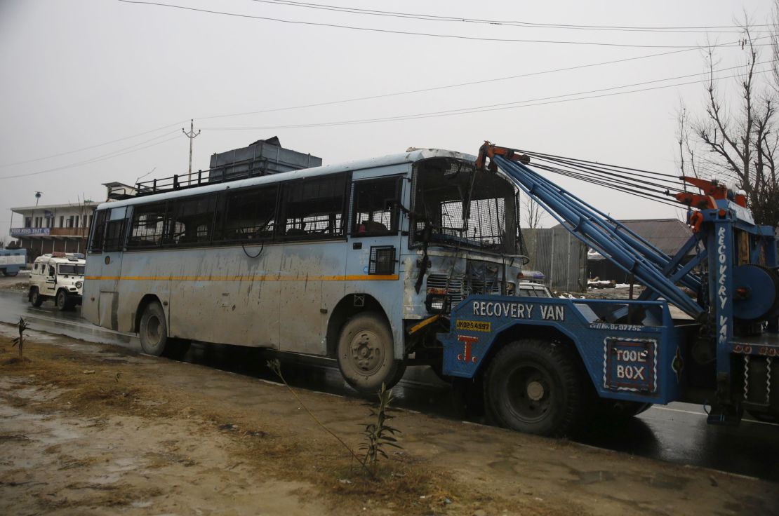 A damaged bus is towed away following the attack.