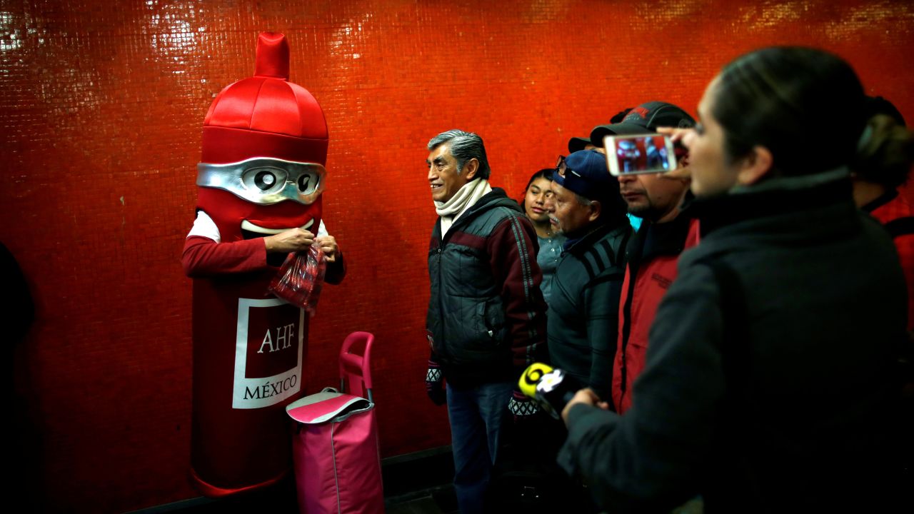 A man in a condom costume gives out free condoms at a metro station in Mexico City on Wednesday, February 13. It was International Condom Day.