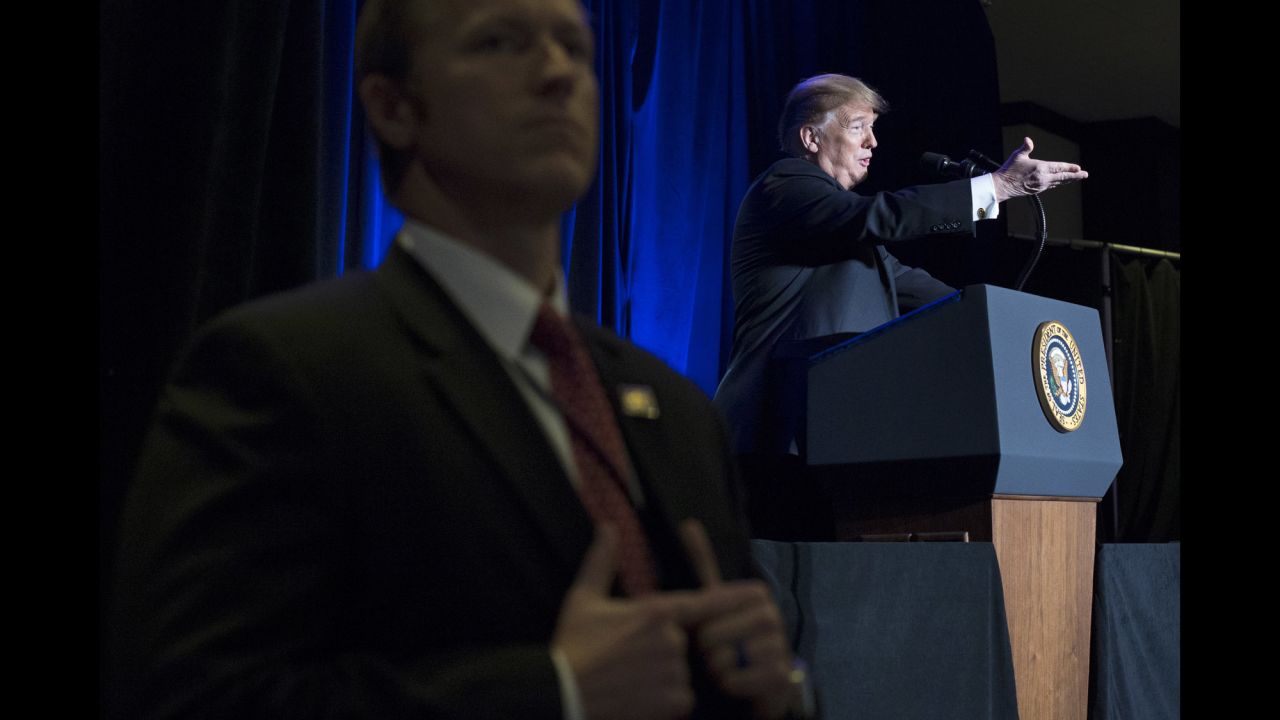 A Secret Service agent stands in the foreground as President Donald Trump delivers remarks to a sheriffs conference in Washington on Wednesday, February 13.