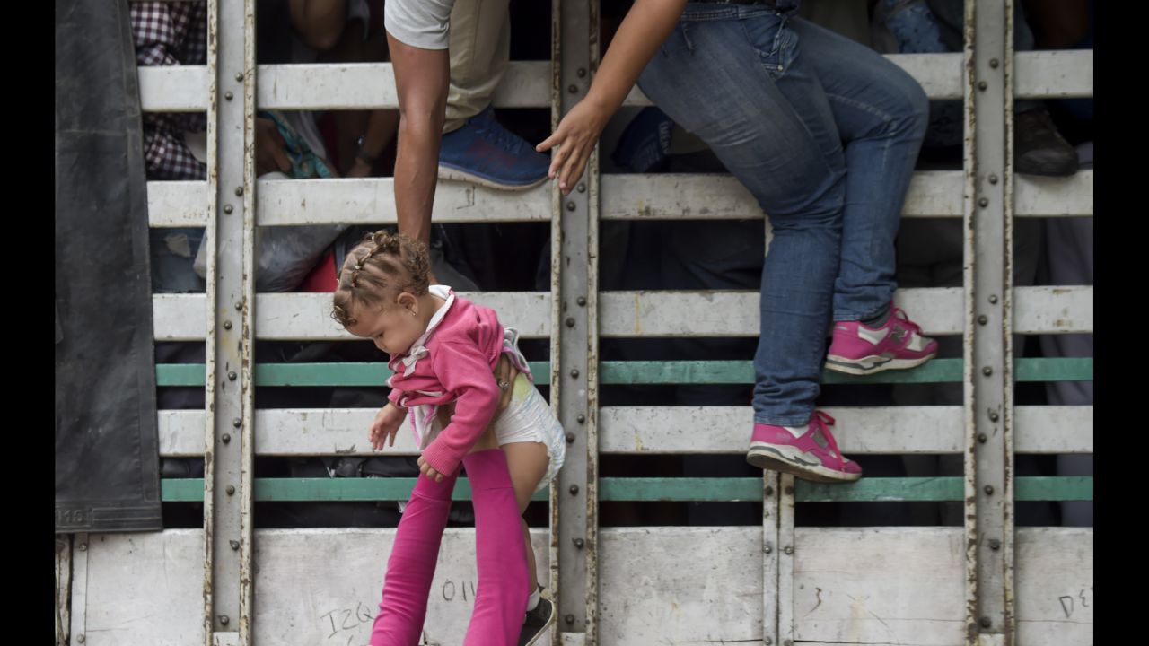 Venezuelan migrants climb on a truck as they travel in Colombia on Sunday, February 10.