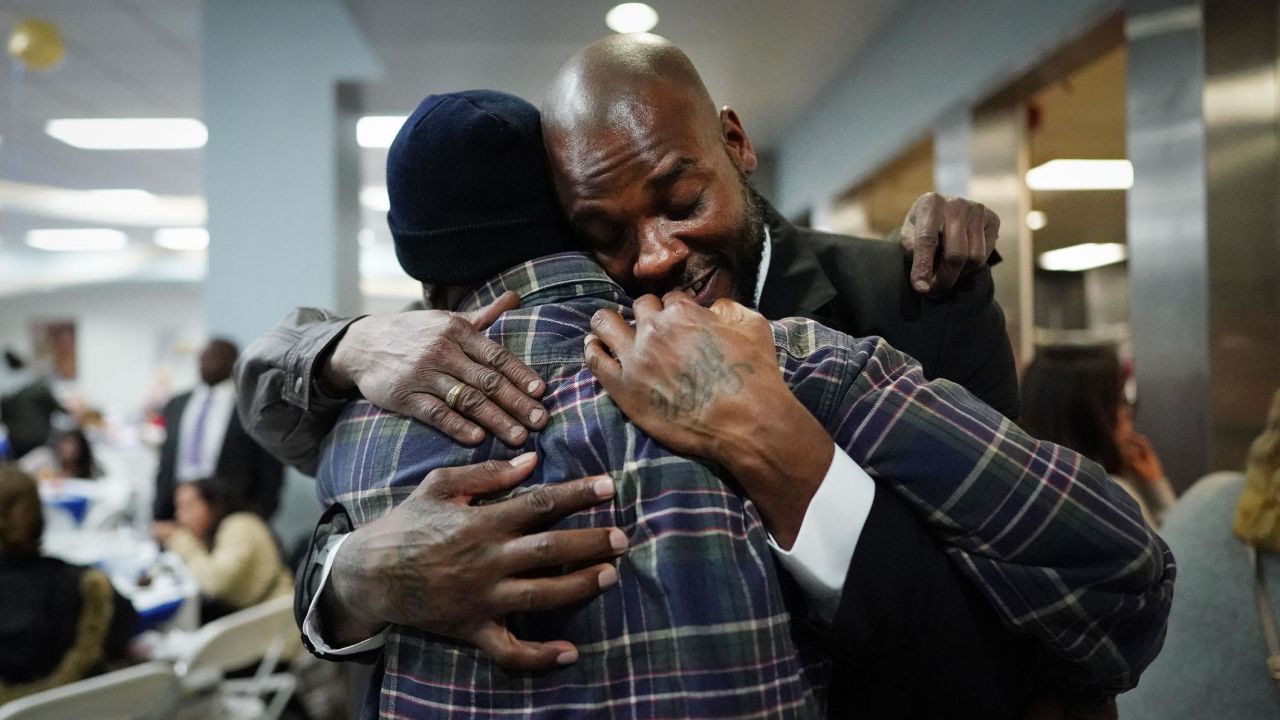 Gregory Harris, right, is hugged by supporters at the Los Angeles Mission after completing a one-year residential program on Friday, February 8. Harris is one of 12 students who were part of the Mission's 100th graduating class. The program helps people recover from challenges such as homelessness, addiction and incarceration.
