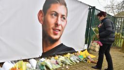 A woman lays flowers beside a portrait of Argentinian forward Emiliano Sala prior to a team training session at the FC Nantes training centre La Joneliere in La Chapelle-sur-Erdre, western France, on January 24, 2019, three days after the plane carrying Sala vanished over the English Channel. 
