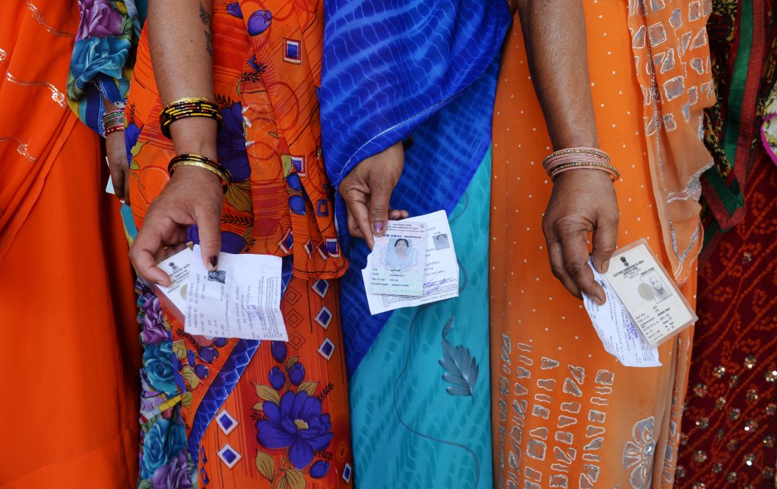 Indian voters stand outside of a polling booth during the last national election in 2014.