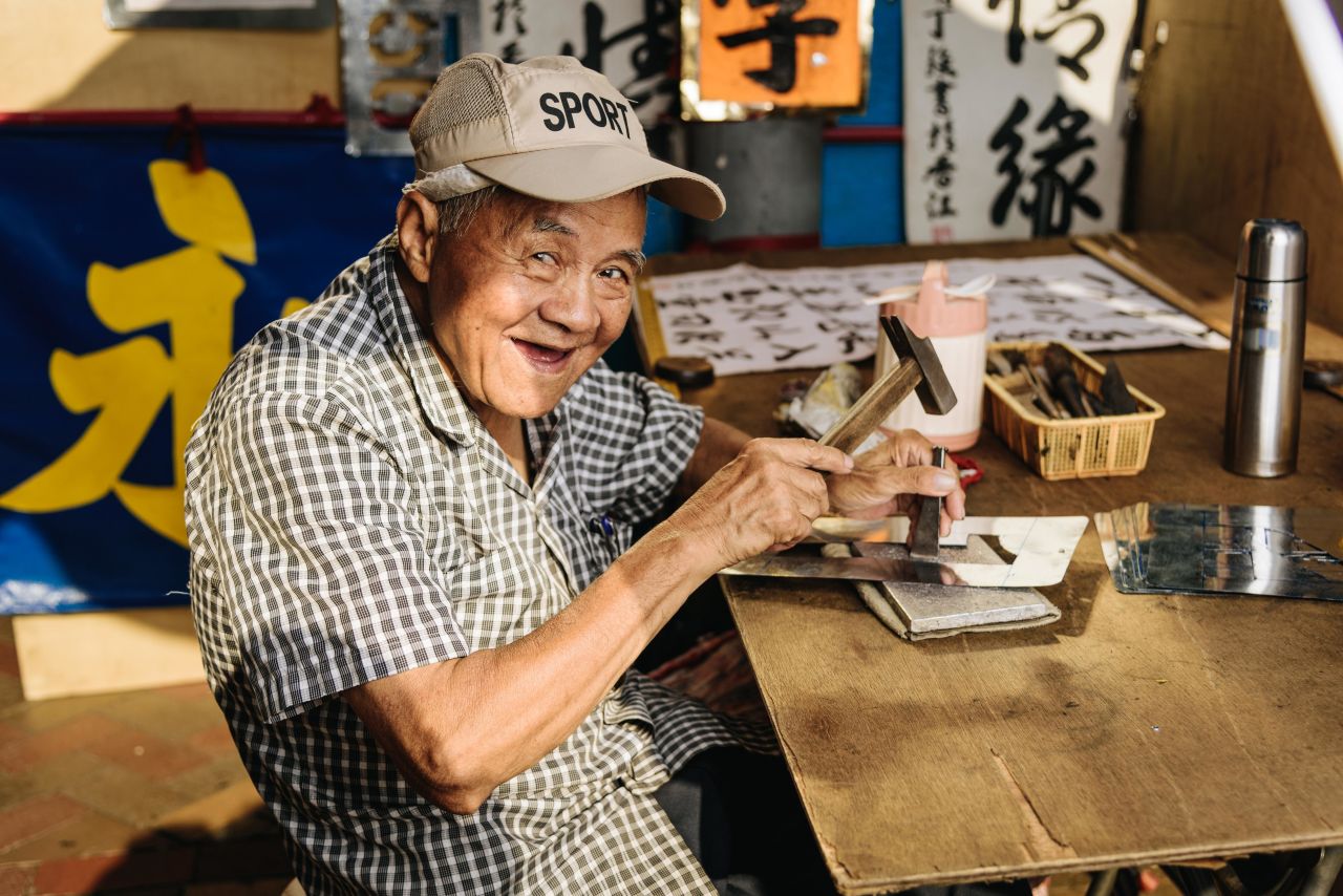 Stencil makers like Wu Ding Keung begin by drawing the Chinese characters onto thin iron sheets, before carefully cutting them out with a hammer and chisel.