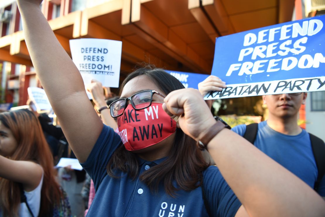 Students hold placards as they shout slogans during a protest at the state university grounds in Manila on February 14, 2019, in support of Ressa.