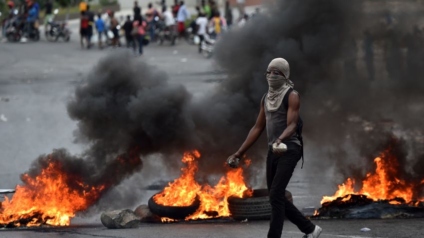 A demonstrator walks past next to barricades during clashes with Haitian police, in Port-au-Prince, on February 15, 2019, on the ninth day of protests against Haitian President Jovenel Moise and the misuse of the Petrocaribe fund. - Since February 7, at least seven people have died as Haiti has been plunged into political crisis, with everyday life paralyzed by protests and barricades in the largest towns. (Photo by HECTOR RETAMAL / AFP)        (Photo credit should read HECTOR RETAMAL/AFP/Getty Images)