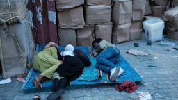 Staff of the Independent National Electoral Commission (INEC) sleep on a ground beside electoral items at a local office in Port Harcourt, Southern Nigeria on February 16, 2019 after Nigeria's electoral watchdog postponed presidential and parliamentary elections for one week, just hours before polls were due to open. - The two main political parties swiftly condemned the move and accused each other of orchestrating the delay as a way of manipulating the vote. (Photo by Yasuyoshi CHIBA / AFP)       