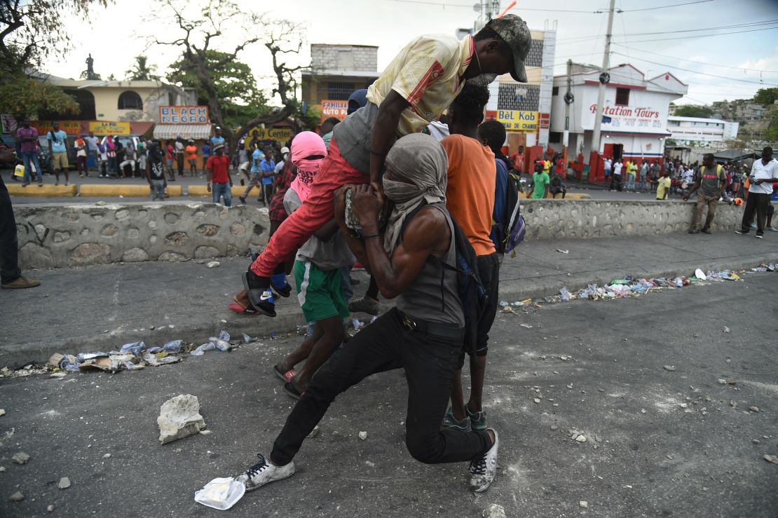Demonstrators try to place a barricade during clashes with Haitian police in Port-au-Prince on February 15.