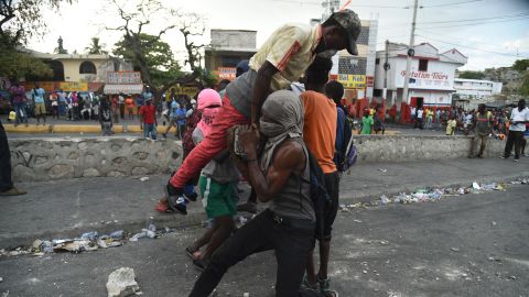 Demonstrators try to place a barricade during clashes with Haitian police in Port-au-Prince on February 15.