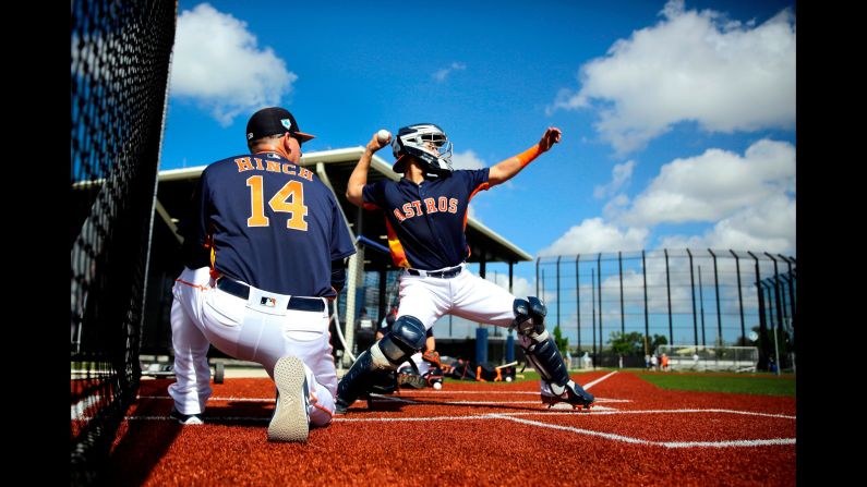Houston Astros catcher Robinson Chirinos practices his throw to second as manager AJ Hinch watches during spring training baseball practice on Friday, February 15, in West Palm Beach, Florida.