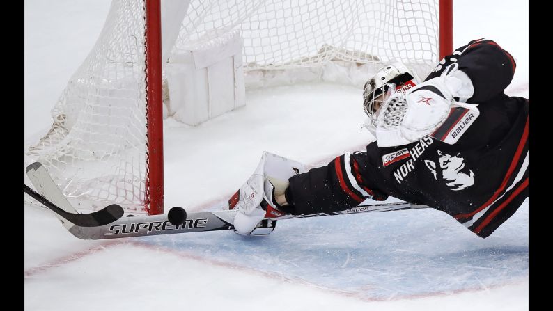 Northeastern goaltender Cayden Primeau dives as he makes a stick save on a shot by Boston College forward Aapeli Räsänen during the third period of the NCAA hockey Beanpot tournament championship game in Boston on Monday, February 11.