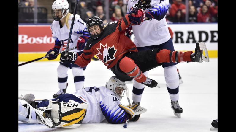 Canada forward Ann-Sophie Bettez is pushed over US goalie Katie Burt after Canada scored during the first period on Thursday, February 14.