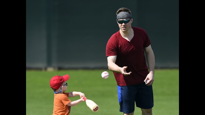 The Boston Red Sox's Brock Holt pitches to his son, Griffin, during a spring training workout in Fort Myers, Florida, on Tuesday, February 12.