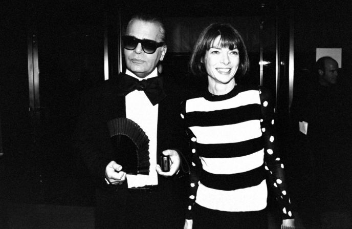 Lagerfeld wears a tuxedo with a large bow tie, accompanied by Vogue publisher, Anna Wintour, at the 12th annual Council of Fashion Designers of America Awards ceremony in New York in 1993.