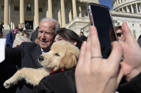 Biden poses for a photo with a dog named Biden as he greets a crowd on Capitol Hill in March 2017.