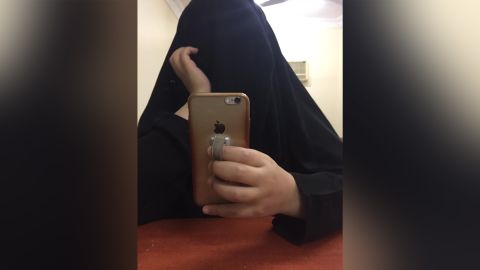 The younger sister takes a selfie in a hotel room. They say they felt like "ghosts" under the full-length black robe, as if they were invisible, not there. 