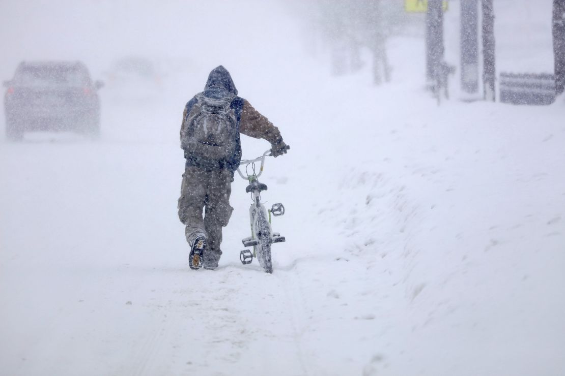 Austin Tauber walks his bicycle through heavy snow in Anoka, Minnesota, on Wednesday. 
