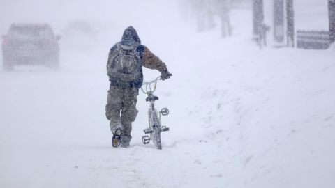 Austin Tauber walks his bicycle through heavy snow in Anoka, Minnesota, on Wednesday.