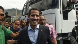 Venezuelan opposition leader and self declared acting president Juan Guaido (C), arrives to take part in a demonstration called by the transportation sector to support him, in Caracas on February 20, 2019. - Opposition leader Guaido has vowed to bring aid in from various points Saturday "one way or another" despite military efforts to block it. (Photo by Federico Parra / AFP)    